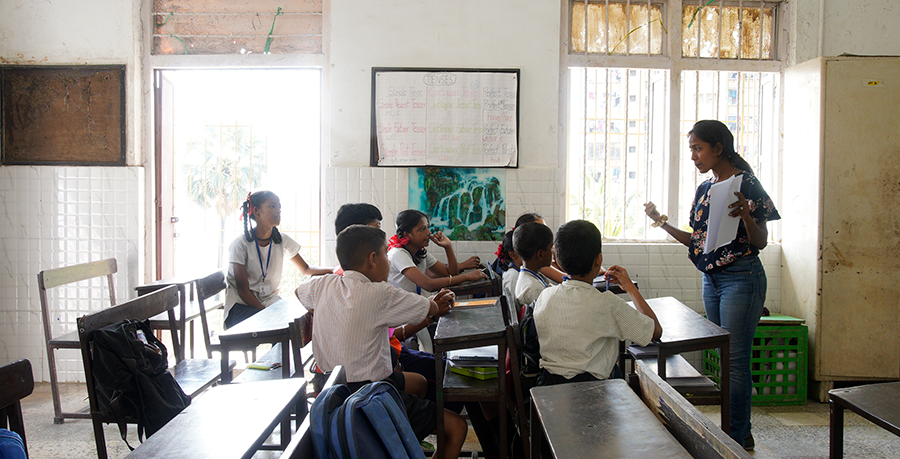 Ein Klassenzimmer in Indien mit einer Lehrerin und interessierten Schülern und Schülerinnen